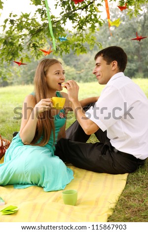 Man feeding a woman under a tree cake