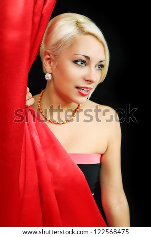 Beautiful actress peeks from behind the curtain