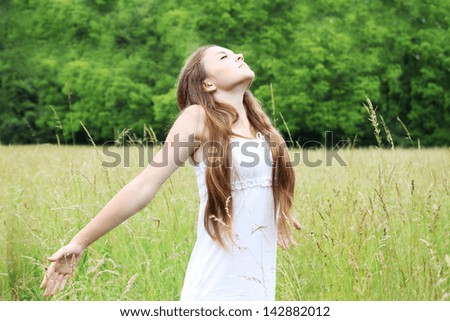Free young woman on the meadow breathes in deeply Free young woman on the meadow breathes in deeply