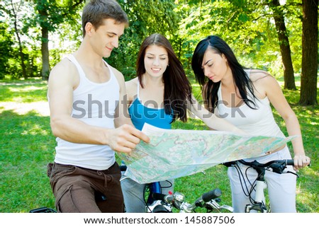 Three cyclists consider the map in the forest