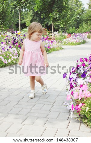 little girl walks on a flowers alley