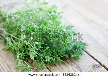 bunch of fresh savory on wooden board
