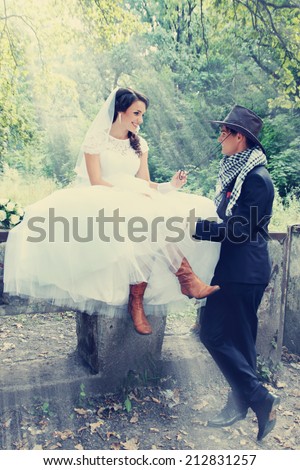 bride flirting with the groom in a cowboy hat