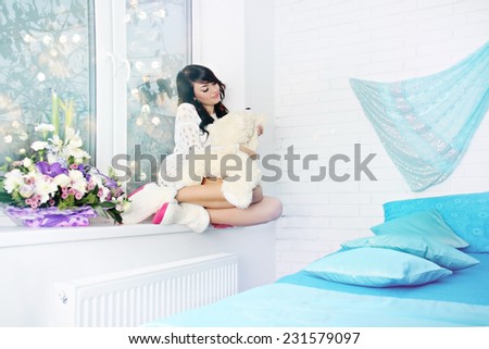 woman sitting on window sill in the bedroom