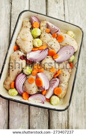 raw chicken and vegetables cooked in a pan for roasting
