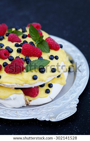 cake Pavlova with raspberries, blueberries and custard