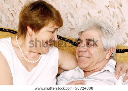 Happy elderly pair contact with each other