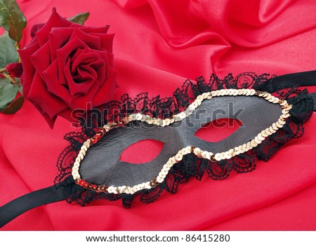 mask with the rose on the red silk