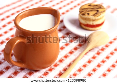 Jug with milk and cake on a saucer.