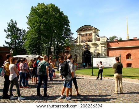 RUSSIA, SAINT - PETERSBURG, Russia - JULY 15, 2014 : guided tours for tourists on the background of the fortress of Peter and Paul - the symbol of the city.