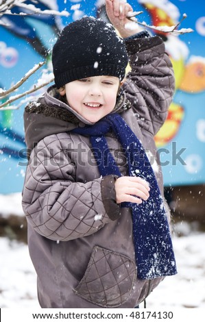 Boy playing in the snow with snow on his face
