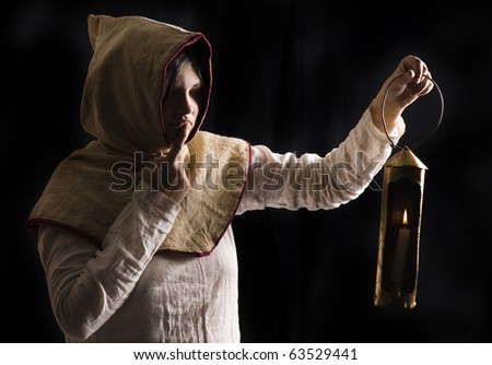 mysterious medieval woman holding a burning lantern