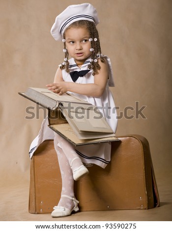 Adorable african girl browsing an family album. Vintage style