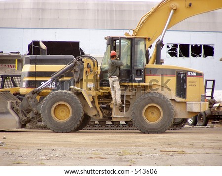 Driver exits loader at construction site.