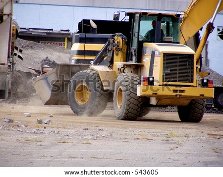 Front end loader drives through construction site.