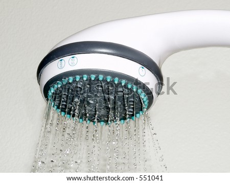 White shower head sprays water.