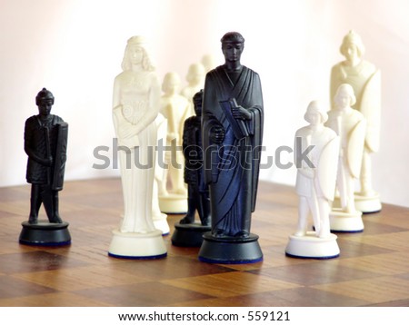Black King and White King stand side by side on wooden chess board.