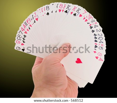 Hand holding fanned deck of cards.