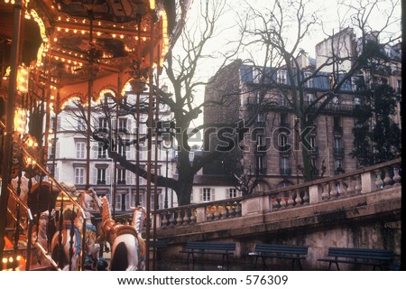 Lonely red merry-go-round in Paris contrasts with gray buildings on cold, dark winter day.