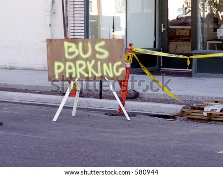 Temporary sign for Bus Parking serves to direct traffic on downtown street.