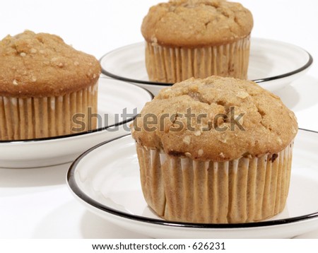 Oat breakfast muffins on saucers against white background.