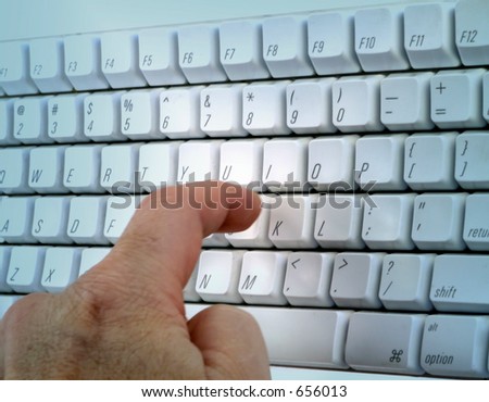 One finger punches key on white keyboard.