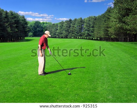 Golfer prepares a fairway shot on a well-manicured course