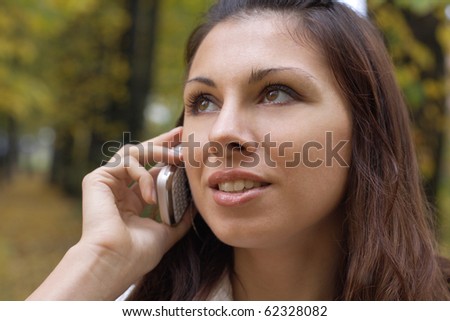 Beautiful girl calling by phone outdoors. More images of this models you can find in my portfolio