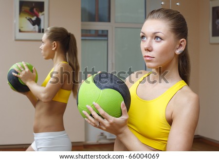 Beautiful blonde girl with ball mirror background fitness gym