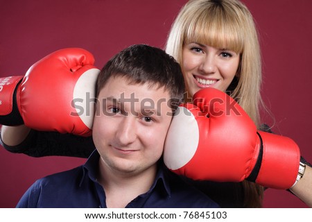 attractive family couple in  boxing gloves on red . cheerful young family have fun with boxing gloves.