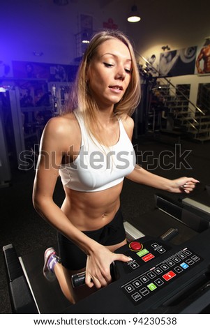 Running woman on toe cam. in top and shorts blue spot background
