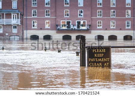 YORK, UNITED KINGDOM - DECEMBER 25, 2013: Flooded pavement in York city center at the bank of the River Ouse, which overflowed due to heavy rains in December 2013. Focus on the sign.