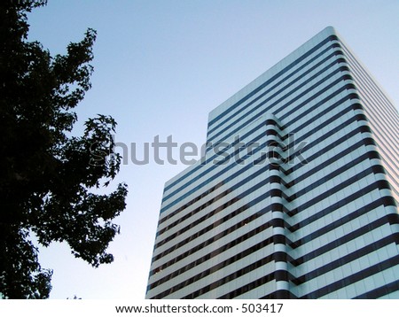 Dark windows stripe across this  classic 90\'s high-rise city building.