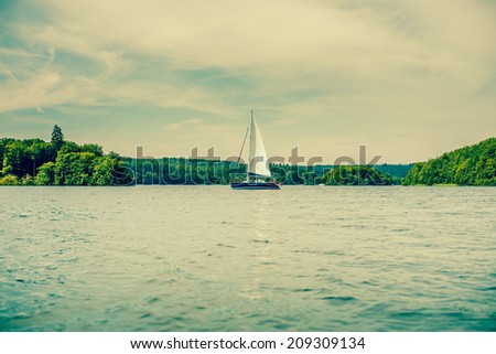 Small sailboat surrounded by water and trees