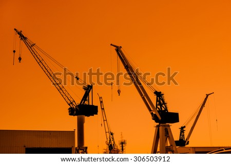 Cranes silhouettes at a shipping harbor in the morning