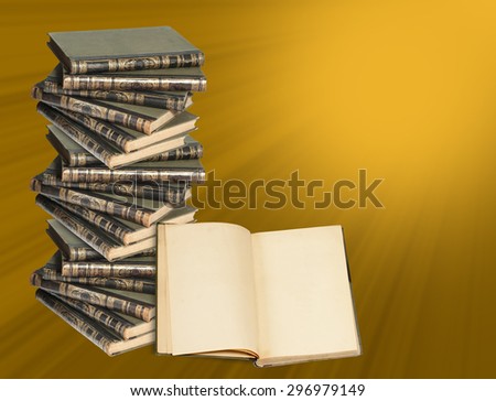 A vertical stack of books and an open book. Many books lie on each other