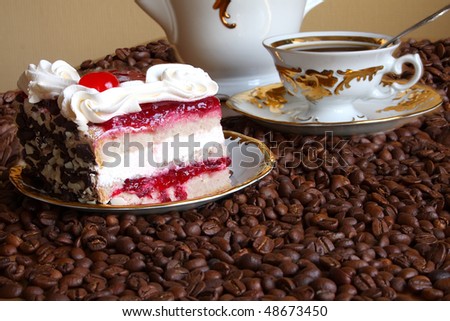 Tasty cake with a cream and a cherry on white ware among coffee grains