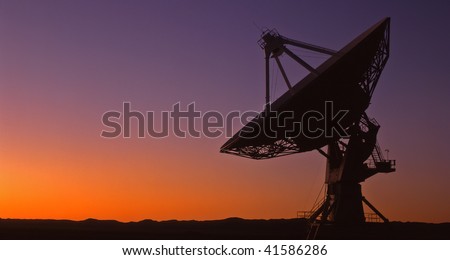 A silhouetted radio telescope, part of the Very Large Array (VLA), in New Mexico.