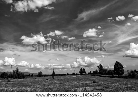 white clouds on the dark sky in  a black and white landscape