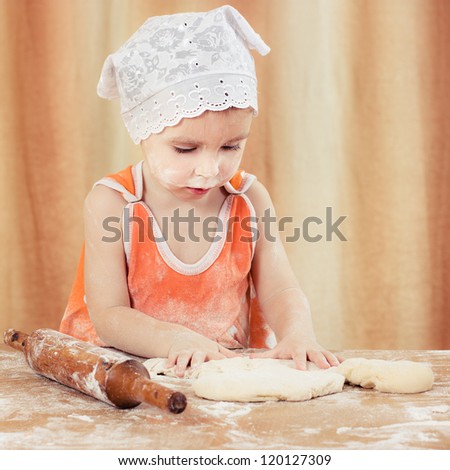 Pretty beautiful girl covered in flour makes cakes.