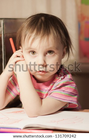 Cute little girl is drawing with felt-tip pen in preschool