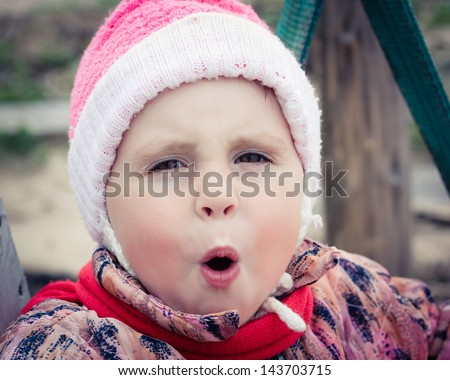 Happy surprised kid wearing warm clothes.