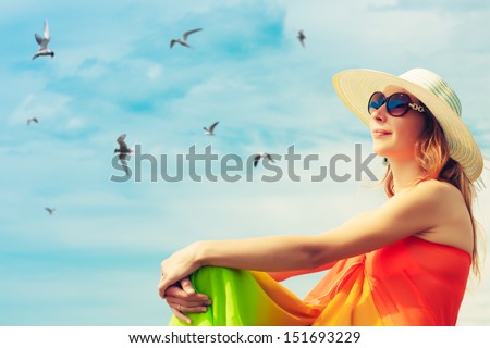 Relaxing beach woman enjoying the summer sun happy in a wide sun hat at the beach with face raised to the sunlight.