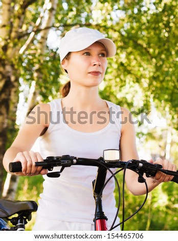 Happy Young Woman riding bicycle outside.