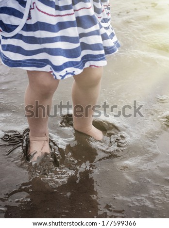 Children\'s bare feet in the mud.