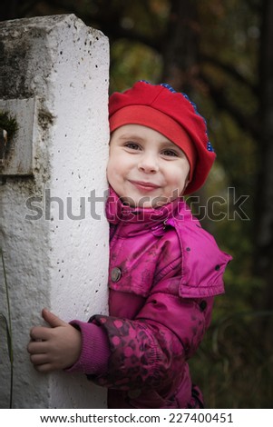 Child looking out of locked wire fencing. outdoors