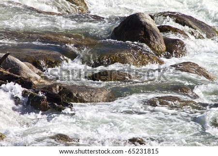A river blured and looking peaceful rolling over rocks in nature