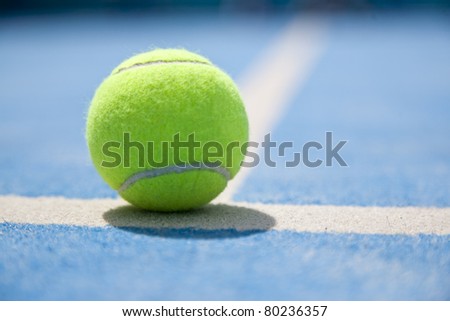 Padel and tennis ball on a court