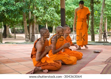 Angkor Wat, Cambodia - 2010, August 9 : A group of orange clad buddhist monks praying in the temple near Prasat Bayon near Siem Reap