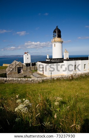 A lighthouse at Dunnet Head, the most northern point of mainland Scotland, with the Orkney Islands in the background